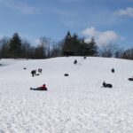 People sledding down a hill.