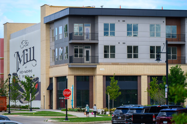 Apartment building with "The Mill" mural on the side.